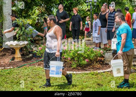 Les adolescents et les enfants se baignent dans l'eau au Thai New Year Festival à Wat Budharangsi, dans la région de Redland, dans le comté de Miami-Dade, en Floride. Banque D'Images