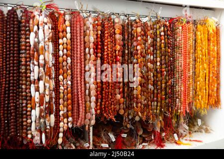 Perles de pierres précieuses accrochés sur le fil dans le magasin d'accessoires de bijoux Banque D'Images