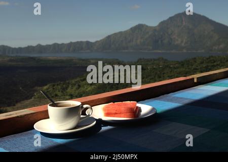 Melon d'eau et thé sur une table de restaurant dans un fond de Mont Batur à Kintamani, Bangli, Bali, Indonésie. Banque D'Images