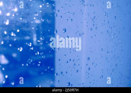 la pluie tombe sur fond bleu de fenêtre. humeur mélancolique Banque D'Images