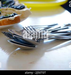 Cuillères et fourchettes en métal dans un tas sur la table. Mise au point sélective Banque D'Images