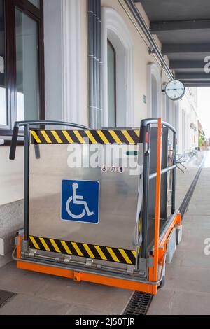 Ascenseur spécial pour fauteuils roulants à la gare. Service d'assistance pour les passagers handicapés ferroviaires Banque D'Images