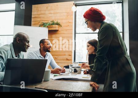 Groupe de divers hommes d'affaires ayant des discussions au cours d'une réunion de conseil d'administration. Professionnels multiculturels partageant des idées créatives dans un include Banque D'Images