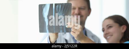 Médecins regardant la radiographie de la main en clinique de près Banque D'Images