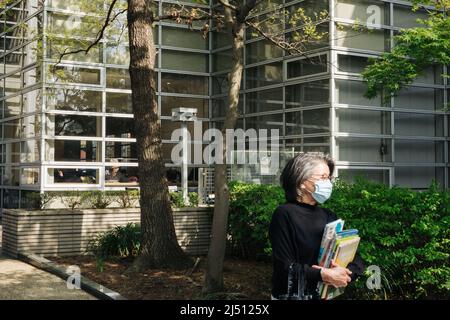 Tokyo, Japon. 10th avril 2022. Un visiteur portant des livres se promène dans un parc de la bibliothèque centrale de la ville de Suginami à Tokyo, au Japon, le 10 avril 2022. Credit: Zhang Xiaoyu/Xinhua/Alay Live News Banque D'Images