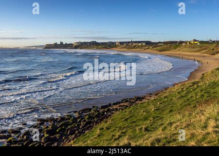 Plage de long Sands à Tynemouth au petit matin du printemps, avec le château de Tynemouth et le Prieuré au loin, Tyne et Wear. Banque D'Images