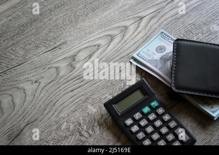 Calculatrice, portefeuille et argent sur table en bois avec espace pour copier. Concept commercial et financier Banque D'Images