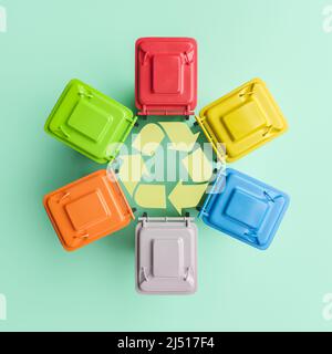 Vue du haut 3D illustration de nombreuses poubelles colorées disposées en cercle autour du symbole de recyclage sur fond de menthe Banque D'Images