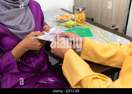 Le couple musulman célèbre la fin du ramadan, le mois Saint islamique, donne de l'argent en cadeau, cherche le pardon, ne montre que des armes et de l'argent Banque D'Images