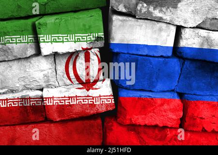 Concept de la relation entre l'Iran et la Russie avec deux drapeaux peints sur un mur de briques endommagé Banque D'Images