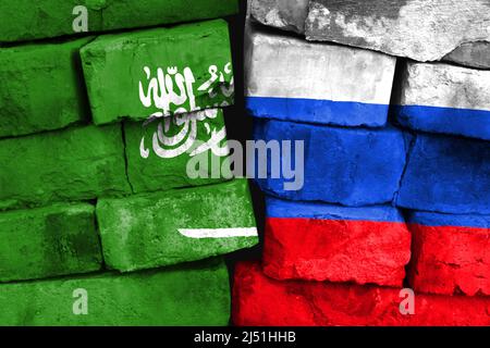 Concept de la relation entre l'Arabie saoudite et la Russie avec deux drapeaux peints sur un mur de briques endommagé Banque D'Images