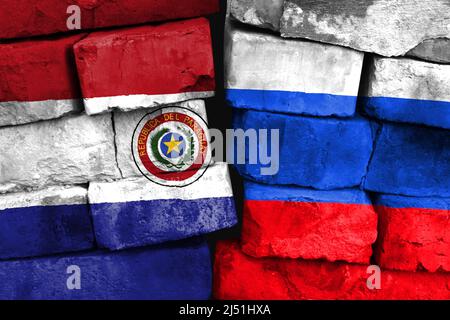 Concept de la relation entre le Paraguay et la Russie avec deux drapeaux peints sur un mur de briques endommagé Banque D'Images