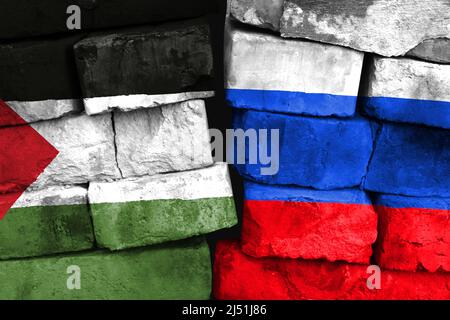 Concept de la relation entre la Palestine et la Russie avec deux drapeaux peints sur un mur de briques endommagé Banque D'Images