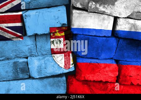 Concept de la relation entre les Fidji et la Russie avec deux drapeaux peints sur un mur de briques endommagé Banque D'Images