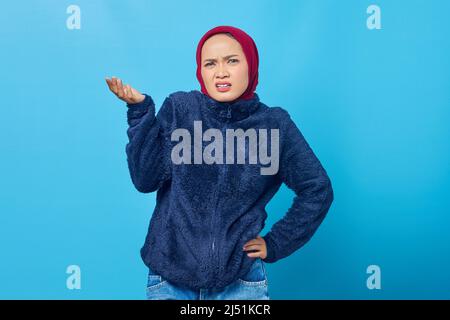 Portrait de la belle femme asiatique se sentant frustrée et agacée sur fond bleu Banque D'Images