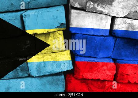 Concept de la relation entre les Bahamas et la Russie avec deux drapeaux peints sur un mur de briques endommagé Banque D'Images