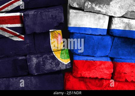 Concept de la relation entre les îles Turques et Caïques et la Russie avec deux drapeaux peints sur un mur de briques endommagé Banque D'Images