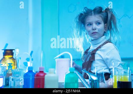 Mignonne petite fille mélange des produits chimiques pendant la leçon de chimie à l'école Banque D'Images