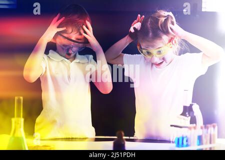 Enfants scientifiques. Les écoliers en laboratoire mènent des expériences. Garçon et fille expérimente avec un microscope. Banque D'Images