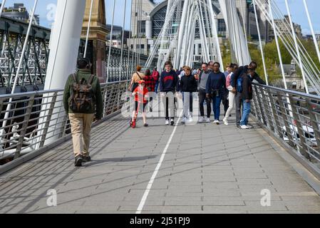 Personnes marchant à travers le Golden Jubilee Bridge, Londres, Royaume-Uni, avril Banque D'Images