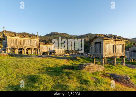 Lumière chaude en soirée sur les greniers et les hangars de stockage en pierre dans le village de Lindoso au Portugal Banque D'Images