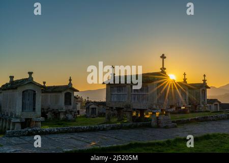 Lumière chaude en soirée sur les greniers et les hangars de stockage en pierre dans le village de Lindoso au Portugal Banque D'Images