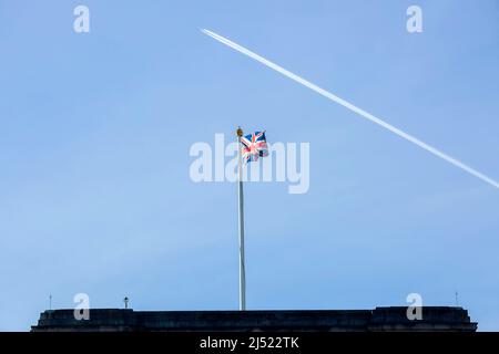 Un contrail est vu au-dessus d'un drapeau de l'Union volant sur le toit de Buckingham Palace dans le centre de Londres avant le jour de l'accession. Banque D'Images