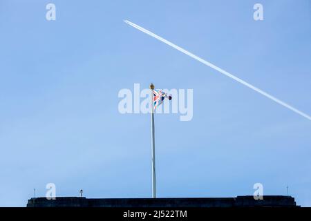 Un contrail est vu au-dessus d'un drapeau de l'Union volant sur le toit de Buckingham Palace dans le centre de Londres avant le jour de l'accession. Banque D'Images