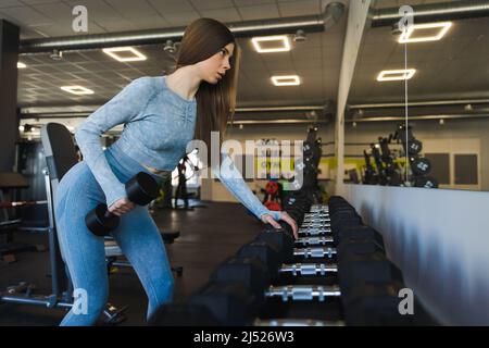 Fille avec des haltères dans la salle de sport Banque D'Images