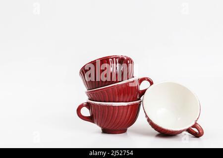 Pile de tasses vintage rouges isolées sur fond blanc. Ressources graphiques Banque D'Images