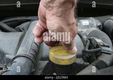 L'homme dévisse le bouchon d'huile du moteur de la voiture. Mécanicien Banque D'Images