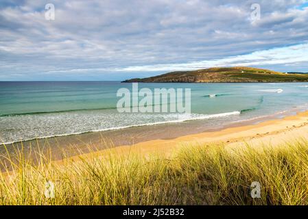 Le soleil brille sur la mer turquoise et les vagues qui se brisent près de la plage de sable vide de la baie de Torrisdale sur la côte nord de l'Écosse. Banque D'Images