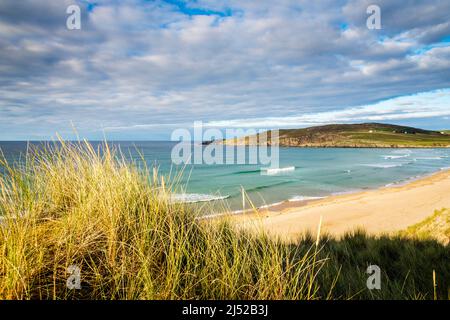 Le soleil brille sur la mer turquoise et les vagues qui se brisent près de la plage de sable vide de la baie de Torrisdale sur la côte nord de l'Écosse. Banque D'Images