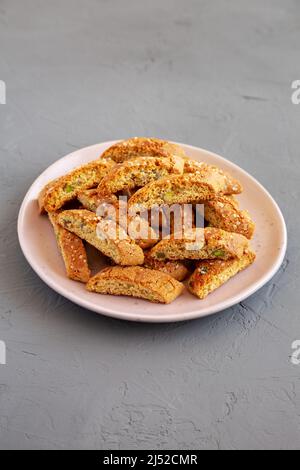 Cantuccini italien maison avec pistaches et citron sur une assiette, vue latérale. Pistaches croustillantes et biscuits au citron. Banque D'Images