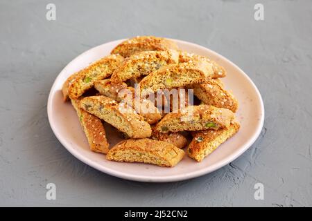 Cantuccini italien maison avec pistaches et citron sur une assiette, vue latérale. Pistaches croustillantes et biscuits au citron. Banque D'Images