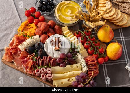 Plateau de fromages et de meze, riche en variété de fruits, fromages, viandes et crackers Banque D'Images