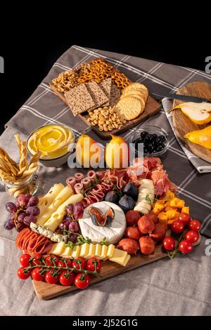 Plateau de fromages et de meze, riche en variété de fruits, fromages, viandes et crackers Banque D'Images