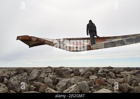 Photographe sur une poutre métallique de pont cassée Banque D'Images