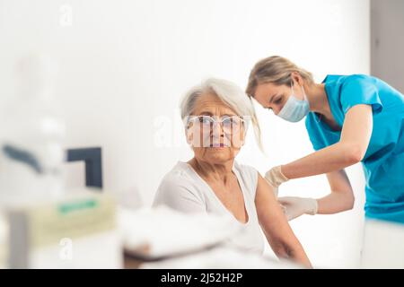 médecin faisant la vaccination à la femme âgée patient moyen de fermer concept de vaccination d'hôpital . Photo de haute qualité Banque D'Images