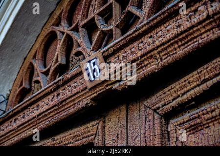 Plaque vintage sur la maison avec le numéro 15. Peinture marron fissurée et taches de rouille. L'adresse de l'ancienne maison est le numéro quinze. Banque D'Images