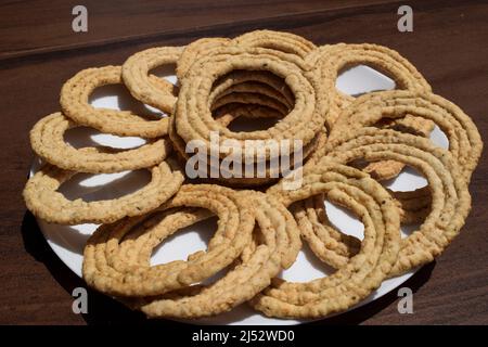 Plat spécial du festival Makar sankranti appelé Sakinalu ou chakinalu. En-cas de telangana indien croquant croquant en forme de Circlel à base de thé dur Banque D'Images