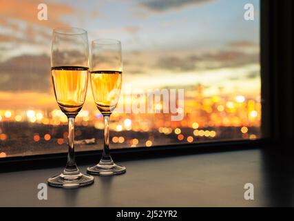 des verres de champagne et une belle vue romantique de nuit de la ville depuis la fenêtre. Banque D'Images