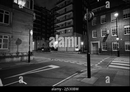 13 avril 2022 - Londonuk : noir et blanc monochrome scène de rue à londres de la traversée piétonne zébrée et jonction avec le grand immeuble d'appartements Banque D'Images