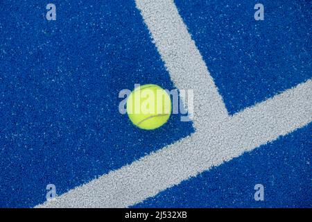 Ballon de tennis sur un court de paddle bleu Banque D'Images