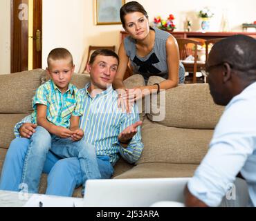 Le travailleur social pose des questions aux parents d'un enfant Banque D'Images