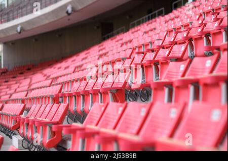 Rangées de chaises en plastique rouge vides dans un stade sportif. Banque D'Images