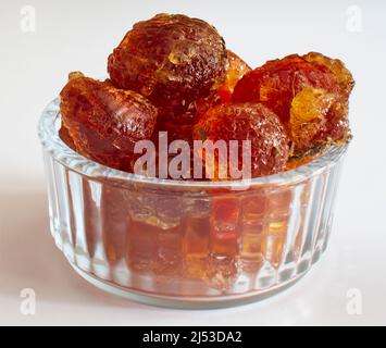 gomme arabique gros morceaux dans un bol en verre gros plan sur fond blanc Banque D'Images