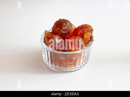 gomme arabique gros morceaux dans un bol en verre gros plan sur fond blanc Banque D'Images