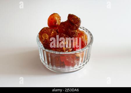 gomme arabique gros morceaux dans un bol en verre gros plan sur fond blanc Banque D'Images