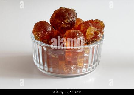 gomme arabique gros morceaux dans un bol en verre gros plan sur fond blanc Banque D'Images